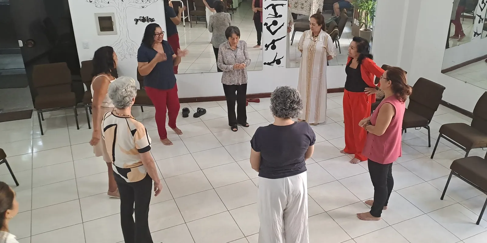 Dinâmica em roda com as participantes de pé, no grupo Longevidade do Ser